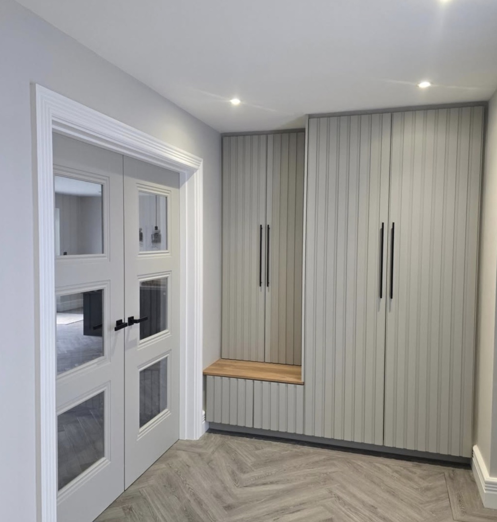 Bespoke boot room with shaker-style fitted wardrobes, oak bench seat and herringbone flooring — Leicestershire