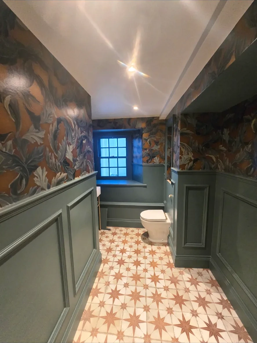 Deep sage green wall paneling and botanical wallpaper in a luxury bathroom — Market Harborough